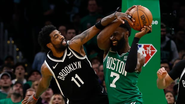Kyrie Irving wears Air Jordan 1 Low 'Travis Scott' sneakers and Jaylen Brown wears Yeezy 700.